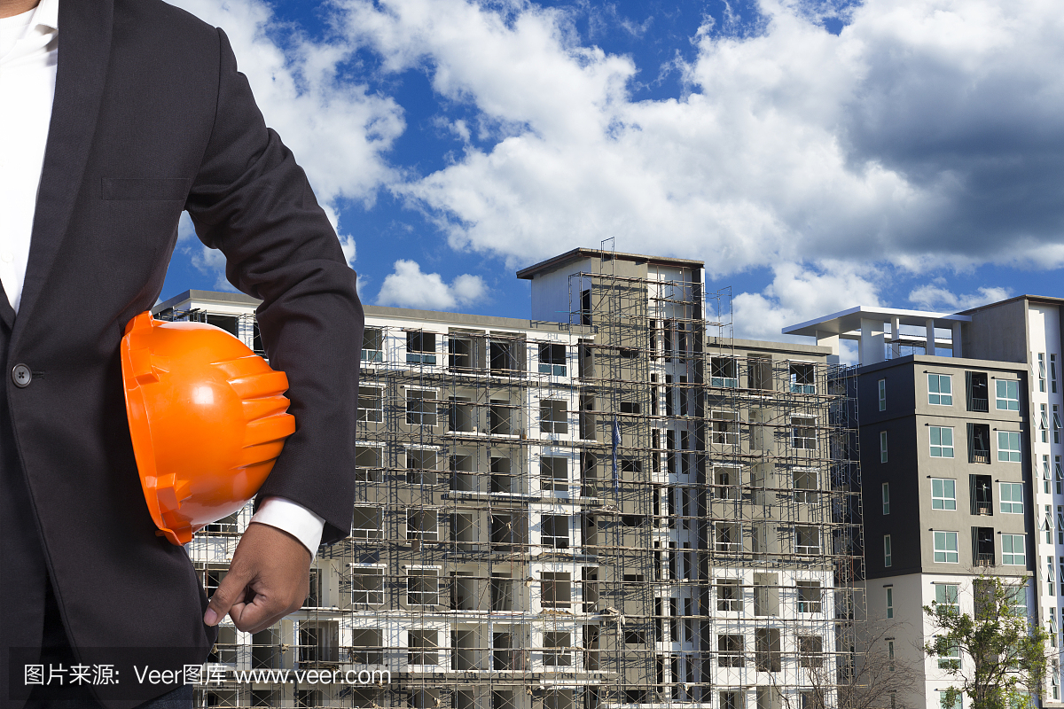 工程師手持安全帽在建筑物基座工作